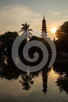 Tran Quoc Pagoda reflecting in lake, Hanoi, Vietnam at sunset