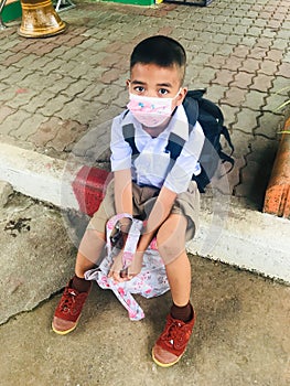 Trang, Thailand - August 6, 2020 : Young student from Banyantakhao school wear surgical face mask to protect covid-19 and waiting