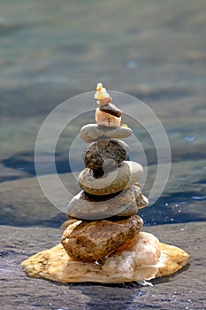 Tranquil beach landscape featuring several small cairns made of rocks and shells on the shoreline,