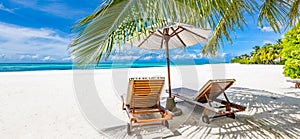 Tranquil beach scene. Panoramic tropical beach landscape for background or wallpaper, two lounge chairs with umbrella