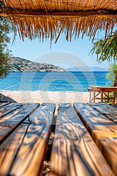 Tranquil Beach View from Under a Thatched Umbrella on a Sunny Day with Clear Blue Water and Scenic Coastline