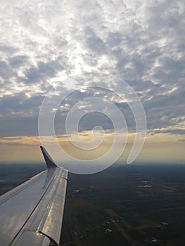 Tranquil Beautiful View From Plane Window at Blue Sky over White Clouds with a Wing