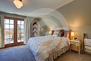 Tranquil bedroom with sloped ceiling and doors to nice deck.