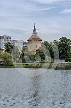 Tranquil body of water with the tower and green trees on the shore. Pildammsparken, Malmo, Sweden