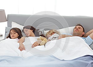 Tranquil children sleeping with their parents