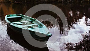 Tranquil evening landscape with river reflecting the sky and old fishing boat