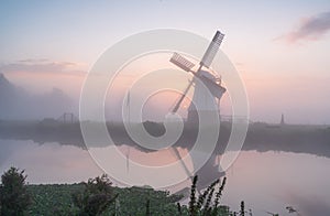 A tranquil, foggy dawn at a windmill.