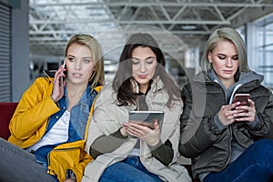 Tranquil girls relaxing with different gadgets