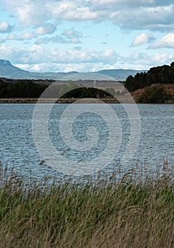 Tranquil Lake and Distant Hills Under Cloudy Skies