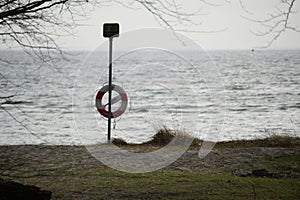 Tranquil lake with life buoy attached to the pole at the shore