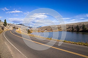 Tranquil Lake Between Road and Hills