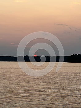 Tranquil lake in South Carolina is illuminated by the red, setting sun