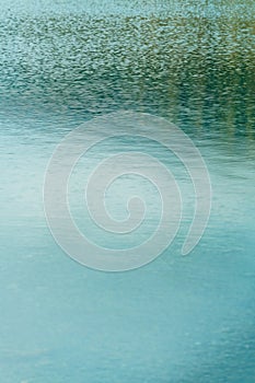Tranquil lake water surface with ripples and reflections photo