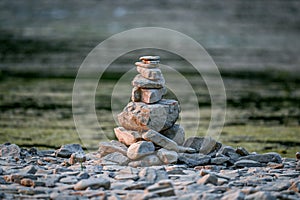 Tranquil landscape featuring a series of stone stacks precariously perched on top of small rocks