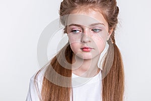 Tranquil light-haired girl with two long tails wearing plain white t-shirt