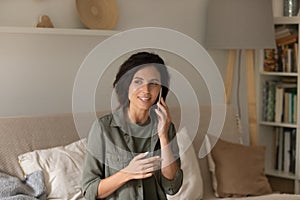 Tranquil millennial female enjoy phone conversation holding gadget at ear