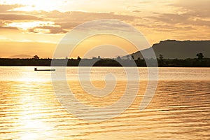 A tranquil morning lake and asian fisherman on fishing boat