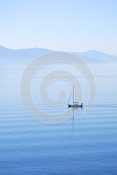 Tranquil morning sea with a sailing ship