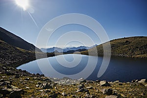 Tranquil morning view of a mountain lake with the sun rising in the backdrop