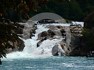 Tranquil mountain river cuts through a rocky valley, creating a cascading stream