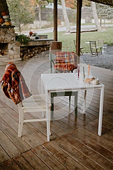 Tranquil outdoor patio with a wooden floor, a traditional picnic table, and two white chairs