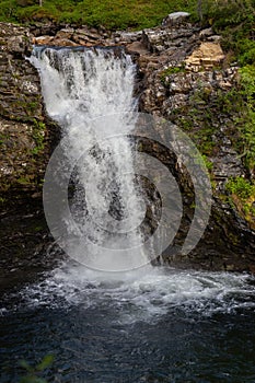 Tranquil and picturesque waterfall cascading down over a rocky landscape in Norway