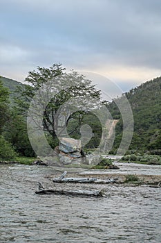 Tranquil river meandering between trees and rocky outcroppings, creating a peaceful scene