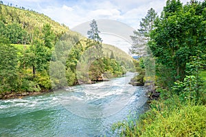 Tranquil scene of a river streaming through an idyllic landscape in the Alps