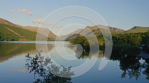 Tranquil Scenery At The Llyn Padarn Lake, with a perfect reflection of a tree in Snowdania Wales UK