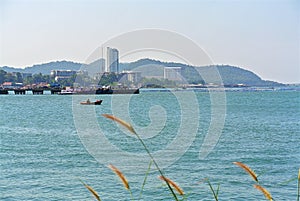 Tranquil Scenery of Small Boat in the Sea with City Buildings on Background