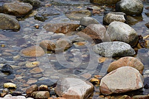 Tranquil stream meanders between the scatteredrocks