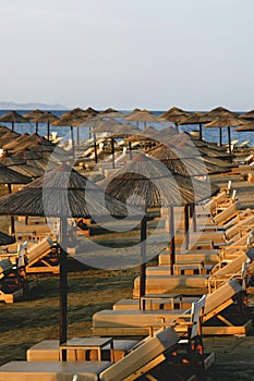 Tranquil Sunrise : Empty Beach Loungers and Reed Umbrellas Await