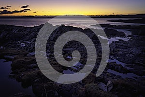 Tranquil sunset scene on rocky beach, on west coast of Scotland