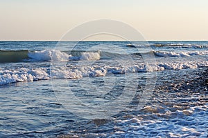 Tranquil surf waves on the beach against clear sky