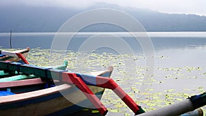 The tranquil view of the lake with calm water and peaceful morning atmosphere. Closeup part of colorful wooden fishing boats