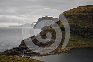 Tranquil view of the ocean on a cloudy day, with mountains in the background