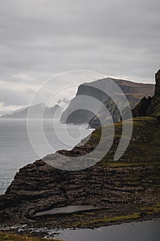 Tranquil view of the ocean on a cloudy day, with mountains in the background