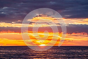 Tranquil vivid sunset with glowing orange clouds.