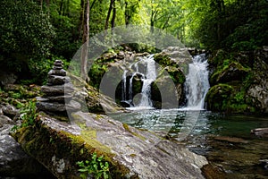 Serene Waterfall and Stone Cairn in Lush Forest