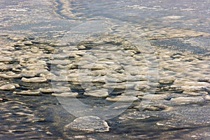 Tranquil winter landscape with snow and ice floes on a frozen lake