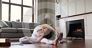 Tranquil woman do seated yoga posture revolved hand to knee