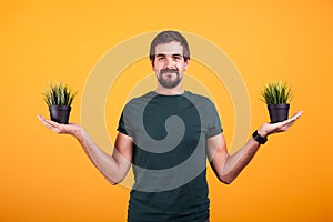 Tranquility concept image of relaxed man holding two pots of grass