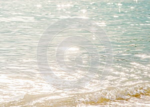 Tranquility time, beautiful surface of seawater in the morning, bright glittering star bokeh, soft waves and bubble. Tropical sea