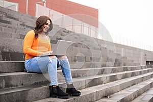 Trans gender student working in laptop in campus outdoors