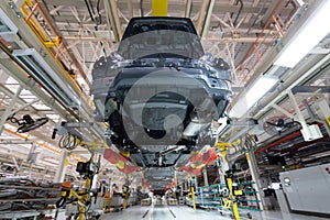 Transfer of car body bottom view. Robotic equipment makes the Assembly of car. Modern car Assembly at factory