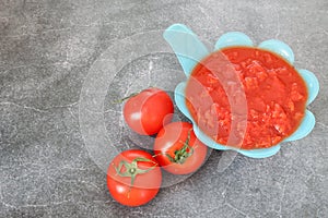 Transfered platchooped tomates from the canning to blue bowl photo