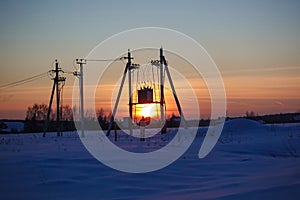 Transformer substation against the backdrop of a beautiful sunset sky. high voltage wires at dusk. power plant at sunset