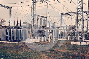 Transformer substation, high-voltage switchgear and equipment. HDR photo of an electric station with poles and wires.