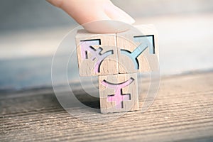 Transgender, LGBT or Intersex Icon On 3 Wodden Blocks On A Board Arranged By A Finger