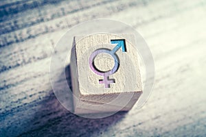 Transgender, LGBT or Intersex Icon With Combined Male And Female Sign On A Wodden Block On A Table